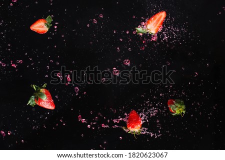 Berry explosion. Strawberry in water splash. Black background