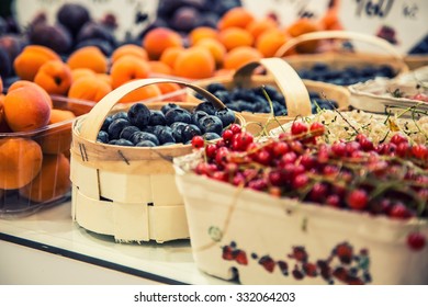 Berry fruits at a marketplace in baskets. Blueberries, raspberries, strawberries, and cherries. - Shutterstock ID 332064203