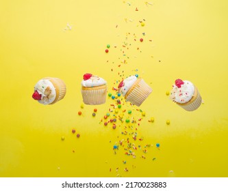 Berry Muffins With Cream And Raspberries On A Bright Yellow Background With Colorful Confetti. Levitation. Minimalism. There Are No People In The Photo. There Is Free Space To Insert.