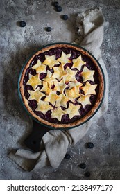 Berry pie decorated with stars on a stone surface top view.