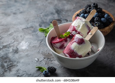 Berry popsicles on rustic background