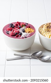 Berry Smoothie Bowl With Raspberries, Peanut Butter And Coconut On A White Tile Background. Raw Vegan Food Concept.