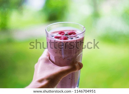 Similar – Mann hält einen Milchshake aus Beeren und Haferflocken.