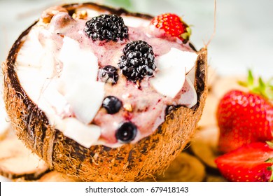 Berry Smoothie With Peanut Butter And Strawberry Sauce In A Coconut Cup.Detox Diet Food And Healthy Lifestyle Concept. Close Up.