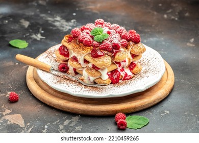 Berry Tiramisu With Biscuit With Coffee Cream And Fresh Berries. Tiramisu With Raspberry On A Dark Background,