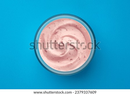 Berry yogurt on blue background, top view