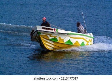 Beruwala Sri Lanka - 09 12 2022 . Small Fishing Boat Driven By The Fisherman To The Sea. Boat Is Made A Left  Turn. Man In The Front Hold On To The Boat. Blue Ocean 
. Photo Taken By Color Collector