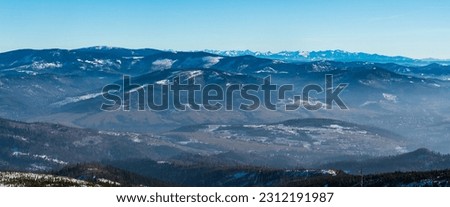 Beskid Zywiecki with Pilsko hill and Tatra mountains with many peaks from Barania Gora hill in winter Beskid Slaski mountains in Poland
