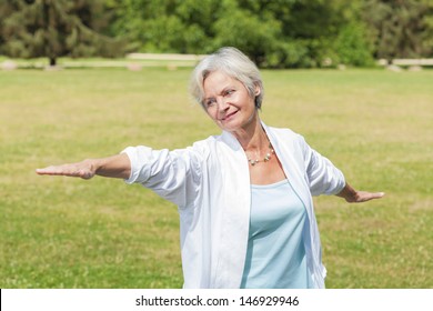 Best Ager Women Practicing Yoga And Tai Chi Outdoors