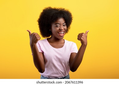 Best choice. Happy african american lady showing thumbs up gesture with both hands, approving or recommending something good, posing isolated on yellow studio wall, banner - Shutterstock ID 2067611396