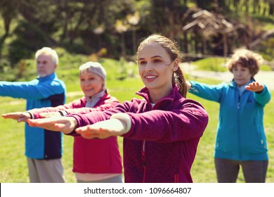 Best day together. Delighted sportive woman smiling and training aged people in the open air - Shutterstock ID 1096664807