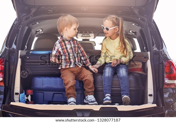 The\
best education you will ever get is traveling. Little cute kids in\
the trunk of a car with suitcases. Family road\
trip