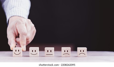 best excellent business services rating customer experience. Satisfaction survey concept. Hand of a businessman chooses a smiley face on wood block cube.  - Shutterstock ID 2208262095