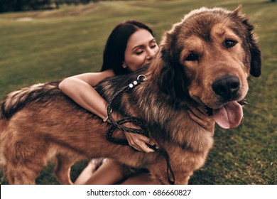 Best friend ever! Beautiful young woman keeping eyes closed while playing with her dog outdoors              ஸ்டாக் ஃபோட்டோ