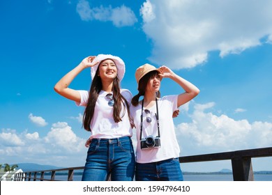 Best Friend Girls In White T-shirt Grab Their Hat Under Blue Sky And Cloud.