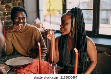 Best Friends Celebrating New Year. Young People With Candles, Sitting At Dining Table. Diverse Students During Christmas Party At Home, Smiling And Laughing.