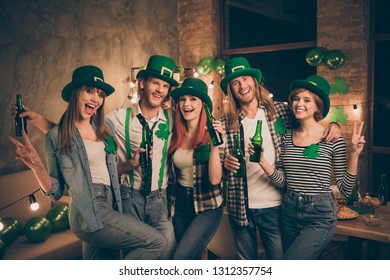Best friends company in traditional national culture irish leprechaun costumes holding hands arms in v-sign drinking beer beverage laugh laughter funny funky best vacation weekend holiday