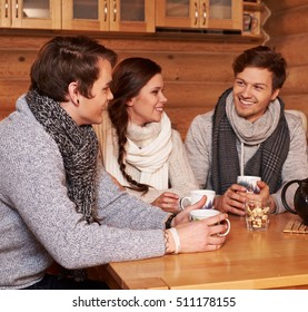 Best Friends Drinking Hot Tea In Cosy Kitchen At Winter Cottage.