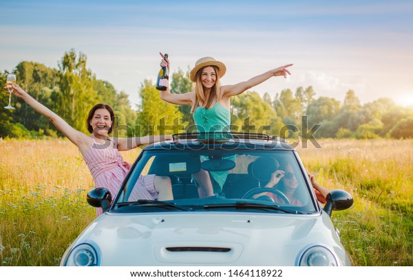 Best friends having fun\
celebrating car ride sunset group happy people outdoors vacation\
nature, friendship youth, concept journey, along with positive\
nostalgic emotions