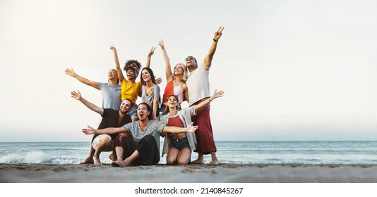 Best friends having fun together at the beach - Group of happy young people with arms up enjoying holiday outside - Teens enjoying spring break party - Summer vacations - Powered by Shutterstock