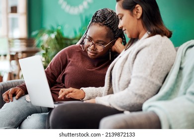 Best Friends Know The Best Fashion Blogs. Shot Of Two Young Women Using A Laptop On The Sofa At Home.