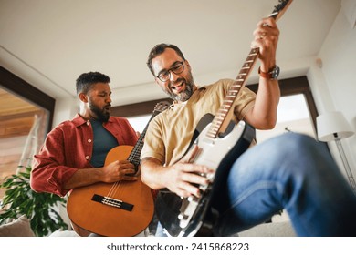 Best friends, musician jamming together. Playing music on guitar together, having fun. Concept of male friendship, bromance. - Powered by Shutterstock