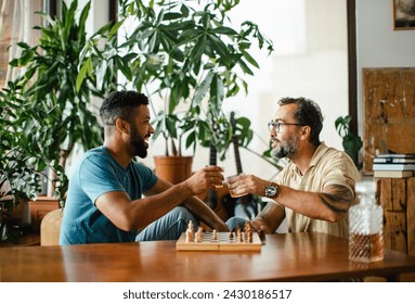 Best friends playing chess together, drinking whiskey and talking. Concept of male friendship, bromance. - Powered by Shutterstock