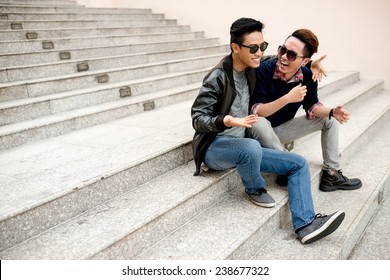 Best Friends In Sunglasses Sitting On The Steps And Laughing