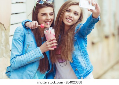 best friends taking a picture yourself in urban city context. 