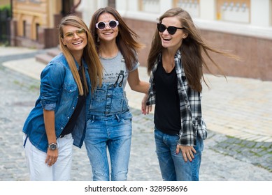 Best friends. Young friends girls are having fun together on the street and smile at each other. Funny and beautiful friends are having a good time together