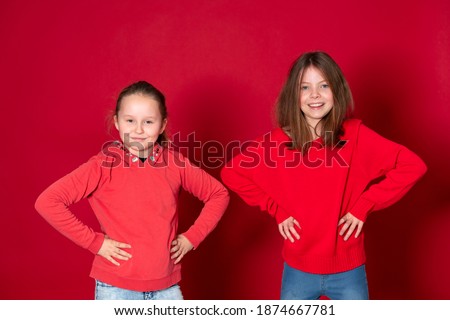 best girlfriends wearing red clothes in front of red background