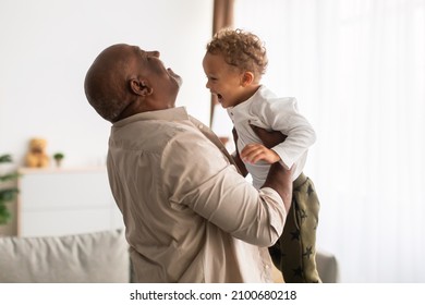 Best Grandpa. Joyful Black Grandfather Lifting His Little Grandson Holding Him In Arms Having Fun At Home. Senior Grandparent Playing With Grandchild On Weekend. Happy Family Moments - Powered by Shutterstock