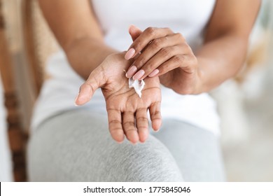 Best Hand Cream For Dry Skin. Unrecognizable Black Woman Rubbing Moisturizing Lotion To Palm, Cropped Image, Closeup