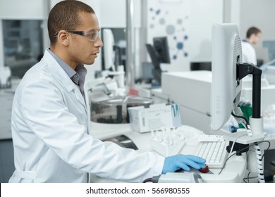 The Best Lab. Handsome Young African Male Laboratory Technician Using A Computer Working In The Lab Medicine Research Analyzer Clinical Chemistry Immunochemistry Efficiency Experience Digital Concept