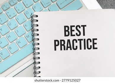 Best practice text on notebook with keyboard background for business strategy and professional standards concept.