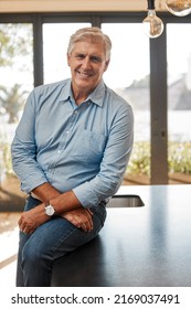 The Best Realtor In Town. Shot Of A Senior Male Realtor Leaning On A Counter At A House.