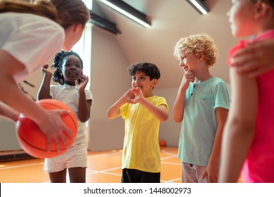 Best teacher. School children smiling to their sports teacher playing basketball in the gym. - Powered by Shutterstock