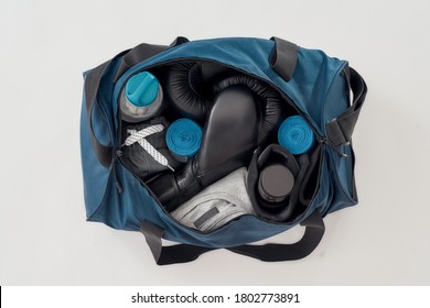 Best Training Equipment. Top View Of A Sports Bag With Boxing Gloves, Hand Wraps, Sport Clothes, Bottle Of Water Isolated On Grey Background. Sport, Fitness, Box. Active Lifestyle