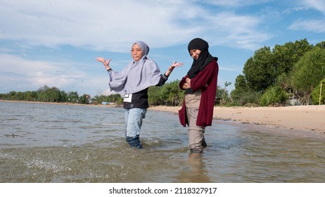 The Bestie Girl Playing Sand On The Beach When Mooring Sun, With Cloudy Sky And Sea Wave. The Photos Is Perfect For Poster, Pamphlet And Banner About Holiday On The Beach.