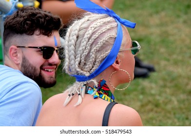 Bestival - September 9th 2016: Headshot Of Man With Sunglasses And Beard Talking To Woman With Blonde Hair In Corn Rows At Bestival, Newport, Isle Of Wight, September 9, 2016 On The Isle Of Wight, UK