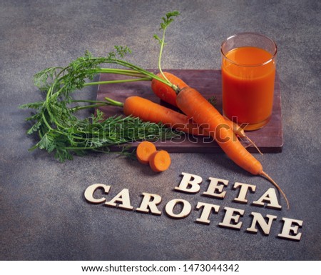 Beta carotene text and carrot juice glass
