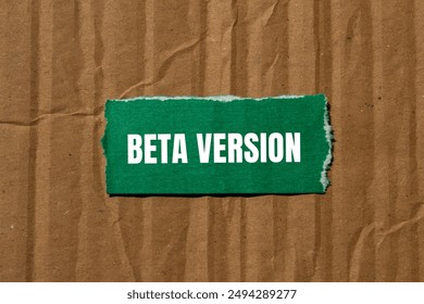 Beta version message written on ripped torn green paper piece with cardboard background. Conceptual beta version symbol. Copy space.