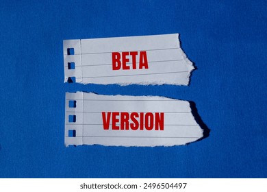 Beta version message written on ripped torn paper pieces with blue background. Conceptual beta version symbol. Copy space.