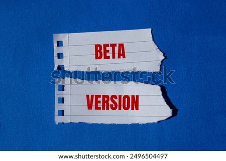 Beta version message written on ripped torn paper pieces with blue background. Conceptual beta version symbol. Copy space.