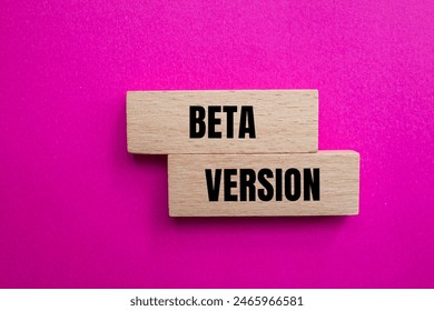 Beta version words written on wooden blocks with pink background. Conceptual beta version symbol. Copy space.