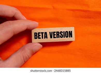 Beta version words written on wooden block with orange background. Conceptual beta version symbol. Copy space.