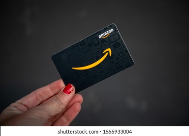 Bethesda, MD / USA - Nov. 10, 2019: A young woman's hand holds an Amazon.com gift card a few weeks before Prime Day and Cyber Monday. 