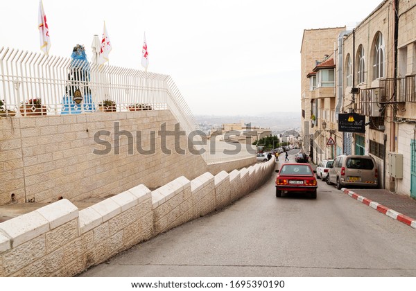 Bethlehem, Palestine / Israel - December 12 2019:\
Wall on Manger Street in Bethlehem, Israel. A car drives along the\
street