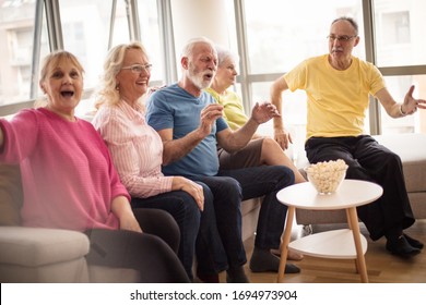 Better Than The Movie Theatre. Group Of Senior People Watching TV At Home.