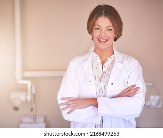 Bettering The World One Smile At A Time. Portrait Of A Female Dentist Standing In Her Office With Her Arms Crossed.